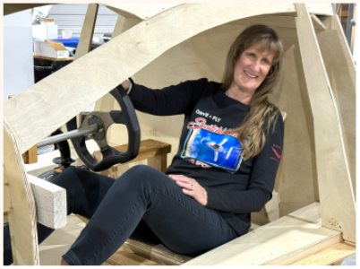 A women sitting inside of a simulator of a flying car