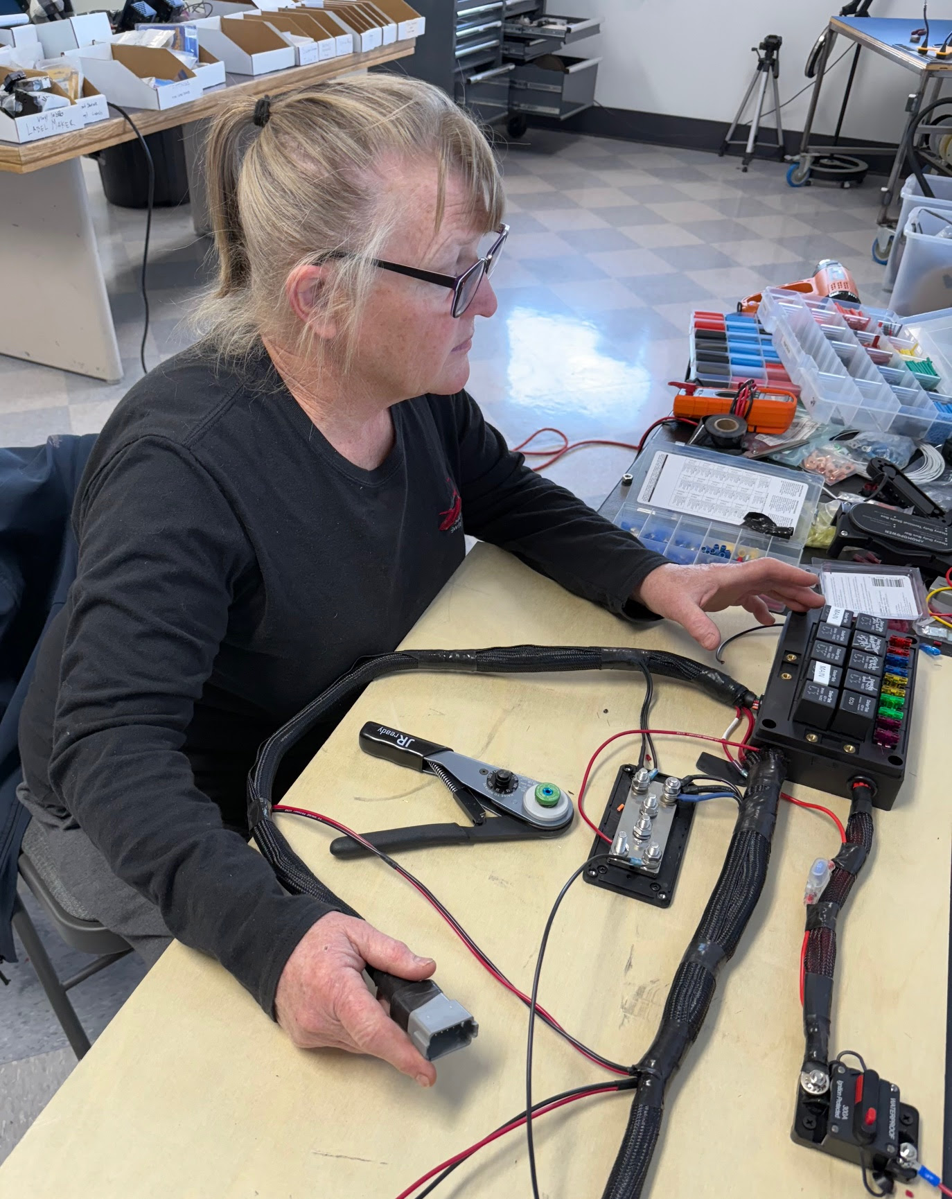 A person at a desk with a bunch of components working on a flying car