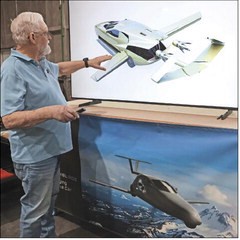 A man pointing to a screen presentation of a flying car render