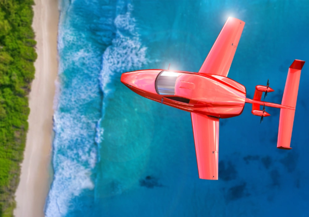 Sleek red amphibious aircraft flying above a tropical beach with turquoise water.