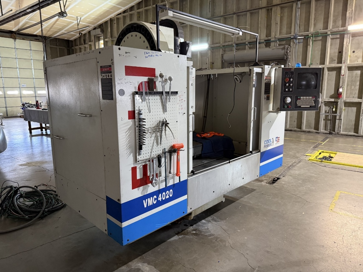 VMC 4020 vertical machining center with tools on pegboard and control panel.